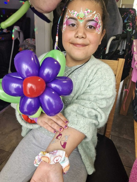 Girl with a floeer balloon and her face painted in Telford
